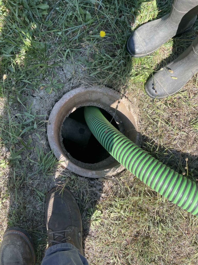 Photo of septic tank pumping with hose in tank